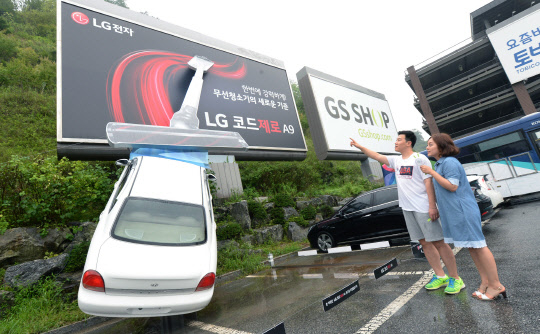 LG전자는 무선청소기 코드제로  A9을 알리기 위해 이색 옥외광고를 26일 선보였다. 이 광고는 코드제로 A9의 강력한 흡입력을 자동차를 빨아들이는 모습으로 형상화해 재치있게 표현했다. LG 코드제로 A9은 LG 청소기 중 최단 기간인 3주만에 국내 판매 1만대를 돌파했다. <LG전자 제공>